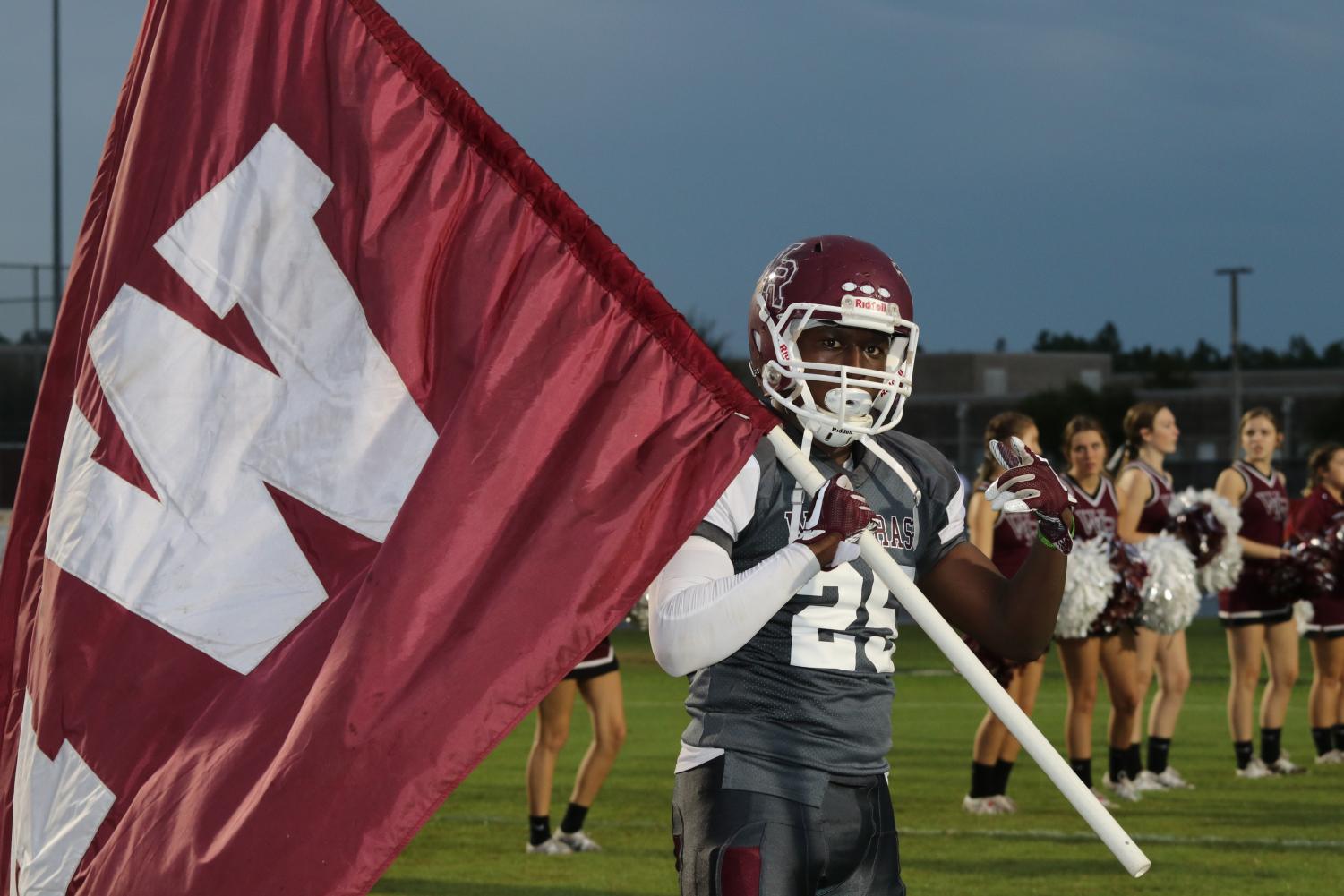 Senior Running Back, Mason Buie, leads the Bulls out of the tunnel waving the Wiregrass flag.