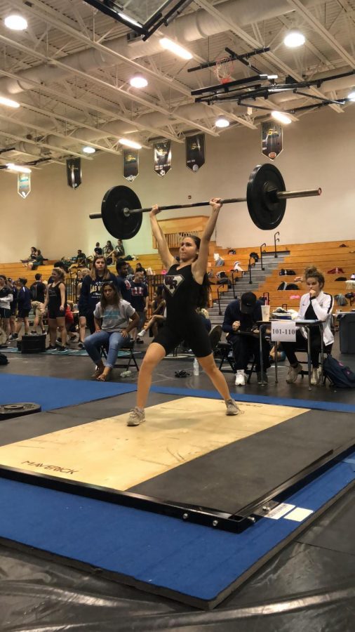 Junior Nicaela Paolinetti performs a clean and jerk to move on to regionals.