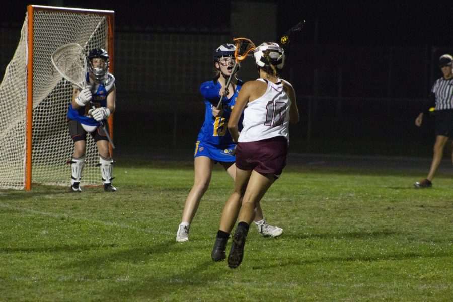 Jenna Kiley (10) rushing the defender and scoring a goal. 