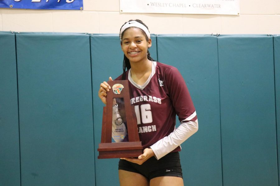 Zoi Evans posing with the district championship trophy after beating Sunlake.