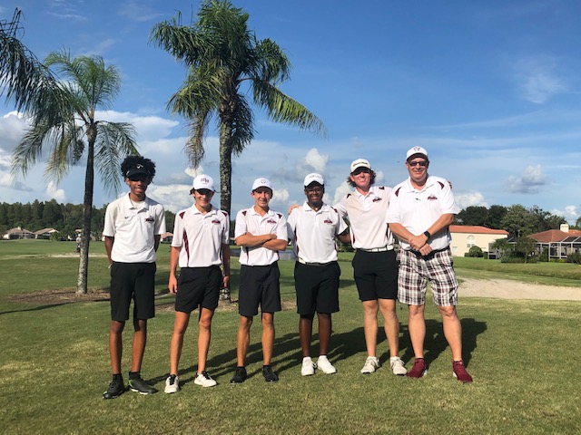 Coach Horrigan poses with boys varsity golf team at meet. 