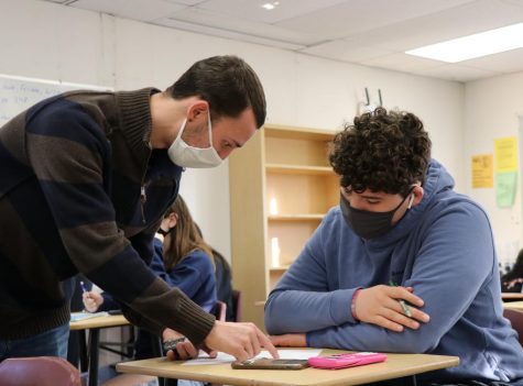 Easton Gorman helping sophomore Ethan Malave work through a problem during class.