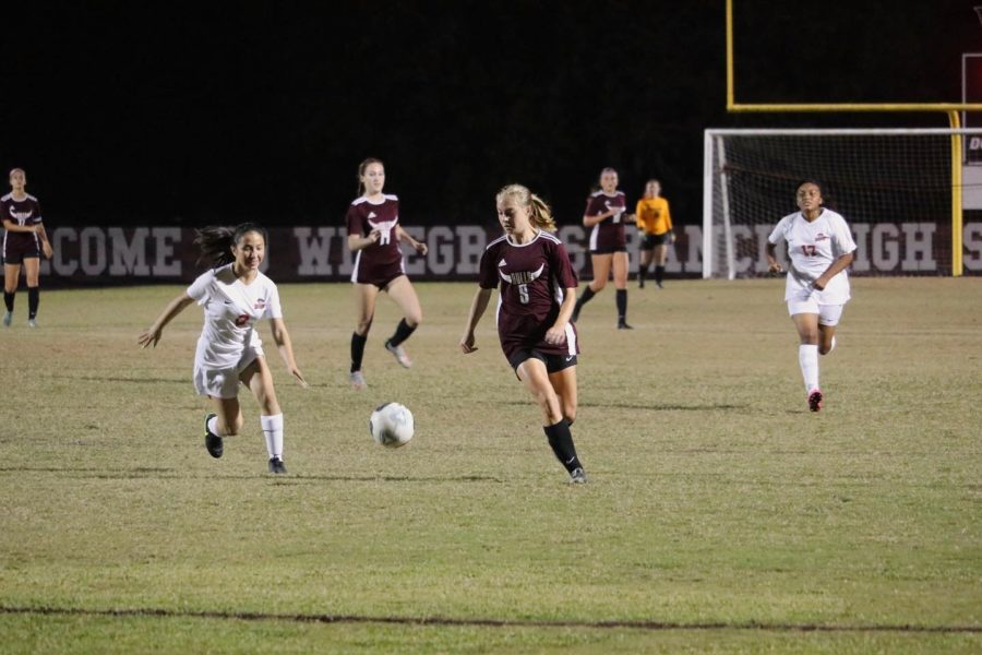 Senior Rylee Humphries (5), moving the ball up the field. 