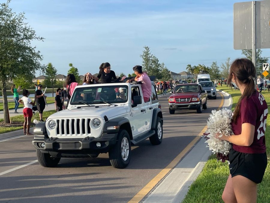 The 2021 seniors wave as they drive through their  car parade.