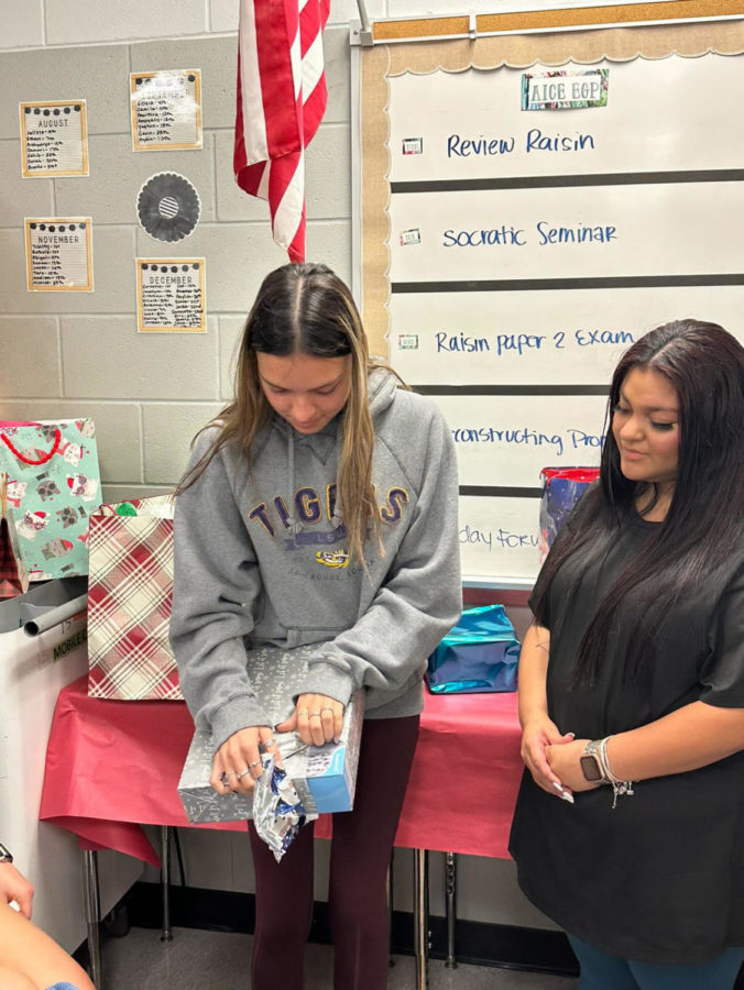 Students at Wiregrass unwrapping gifts for secret santa.