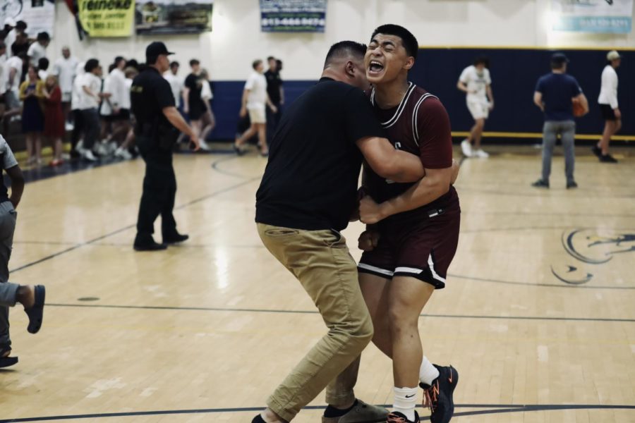 Junior guard Jordan Roque embracing his father after the district championship win.
