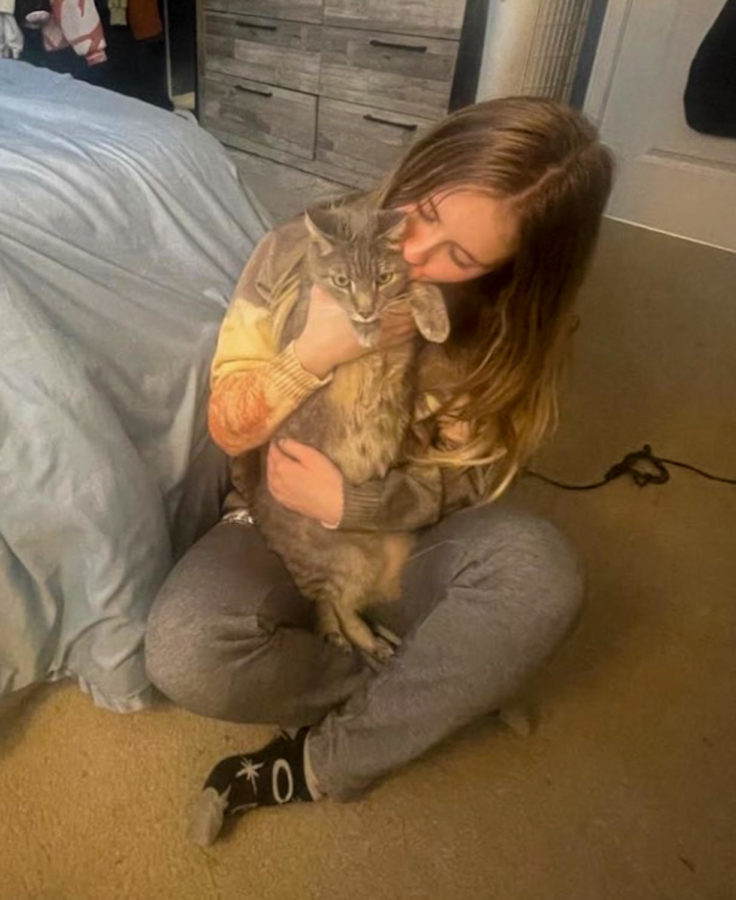 Senior Sienna Paras cuddles her large grey cat, Smokey.