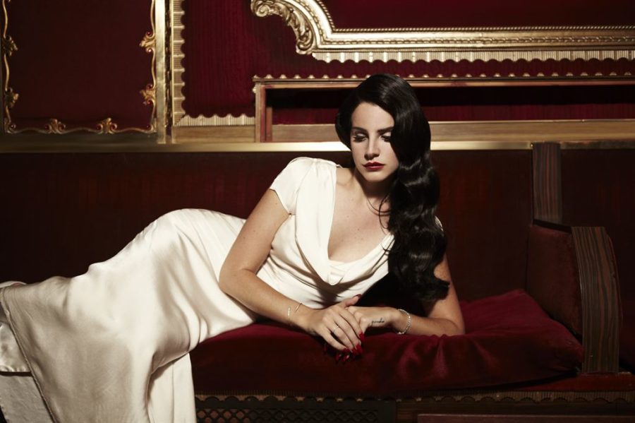 Lana Del Rey posing for a photo shoot, where her old-Hollywood glam style is prominent.